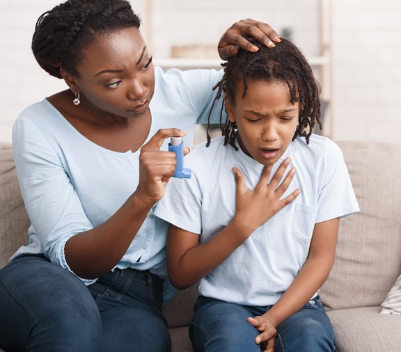 child with asthma and mom helping