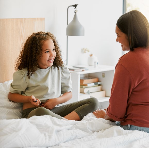 Caring mother teaching child to take insulin injection by herself looking happy, proud and brave at home. Little girl injecting self with blood sugar measuring device to test for chronic illness
