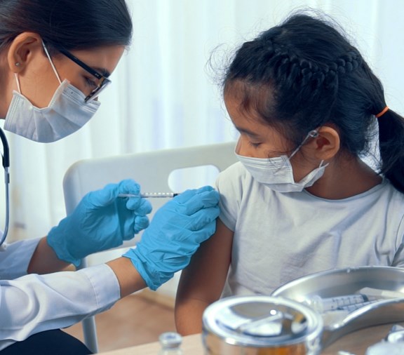 Young girl getting a vaccine from a pediatrician